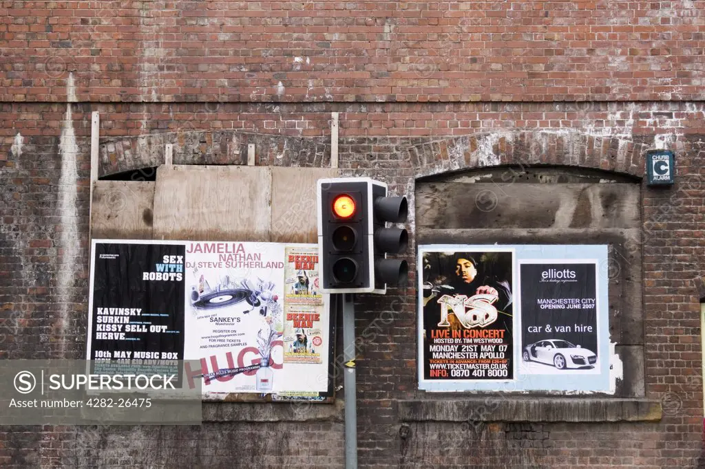 England, Greater Manchester, Manchester. Traffic light and fly posters in Manchester.