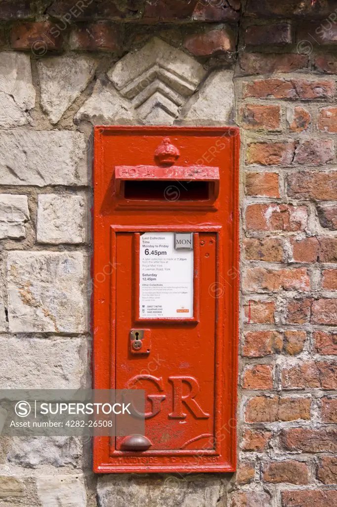 England, North Yorkshire, York. A traditional red post box in a wall.
