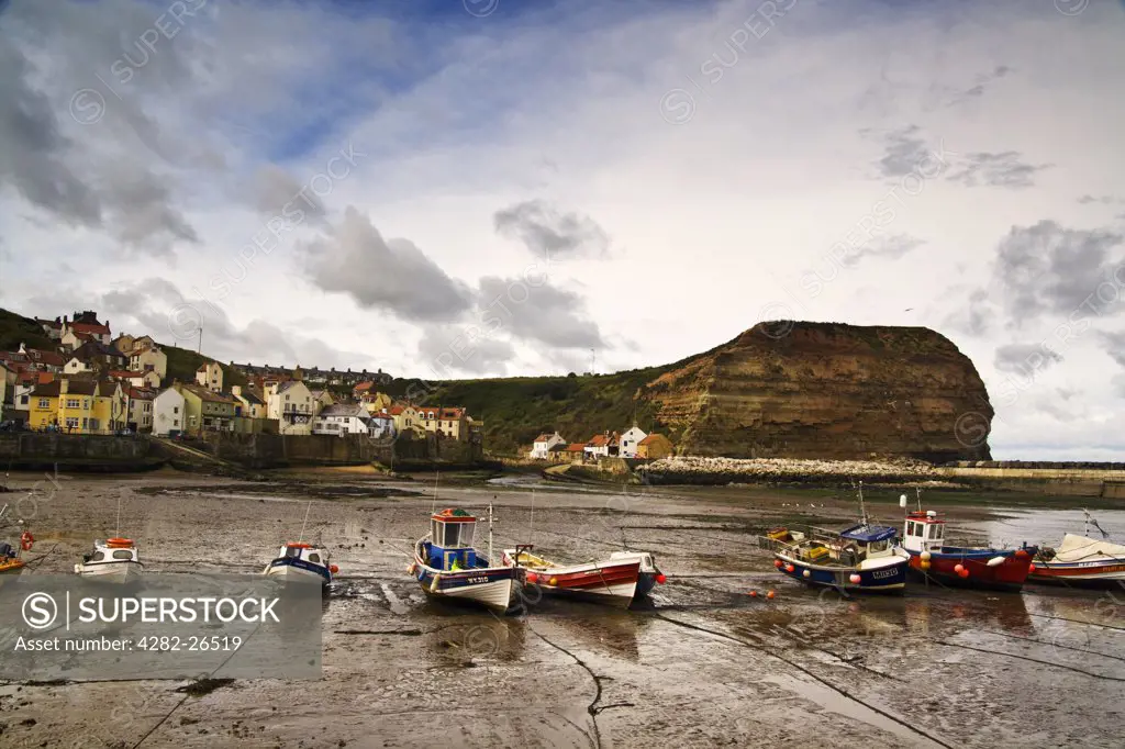 England, North Yorkshire, Staithes. Fishing boats in Staithes harbour at low tide.