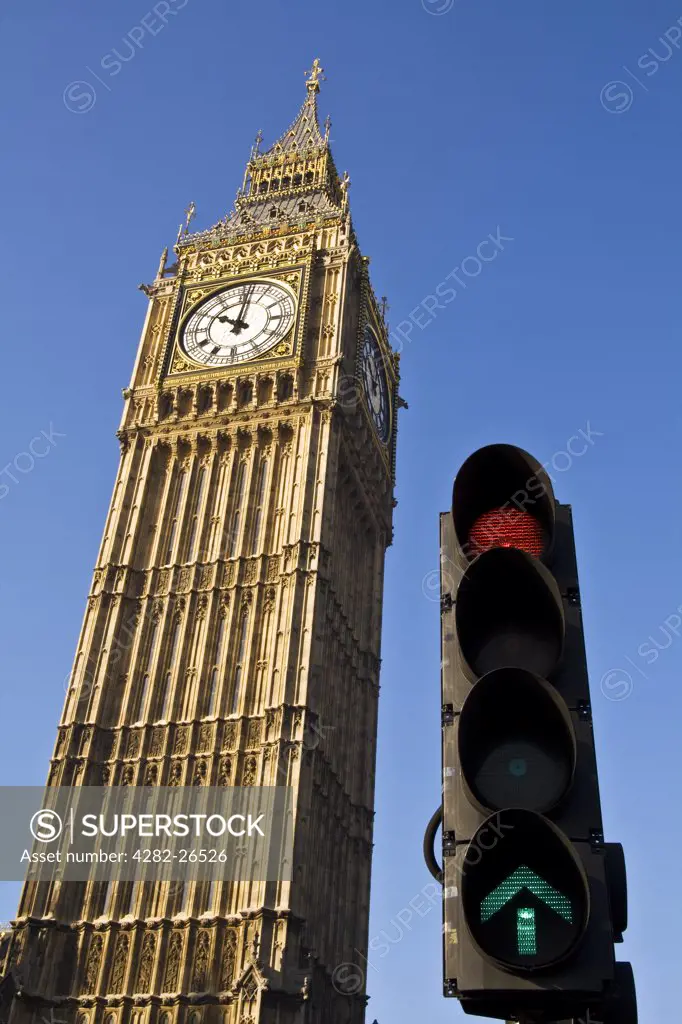 England, London, Westminster. Big Ben and traffic light set against a clear blue sky.