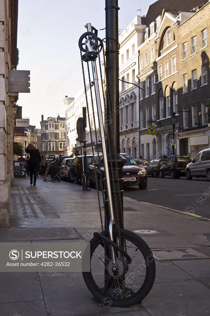 England, London, London. A unicycle chained to a lampost.