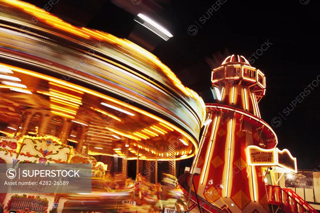 England, London, London. Light trails from a carousel as it whizzes round in a fairground at night.