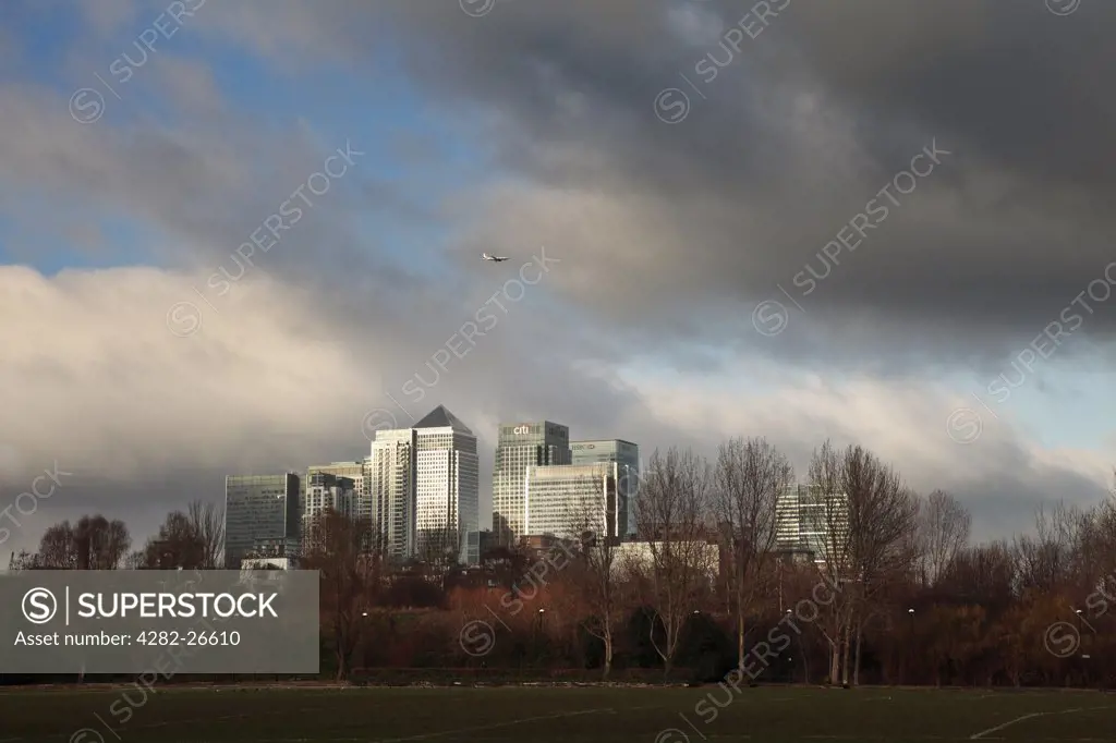 England, London, Docklands. Stormy skies over the Canary Wharf office and shopping development from Millwall Park on the Isle of Dogs.