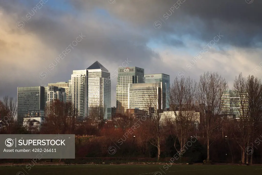 England, London, Docklands. Stormy skies over the Canary Wharf office and shopping development from Millwall Park on the Isle of Dogs.