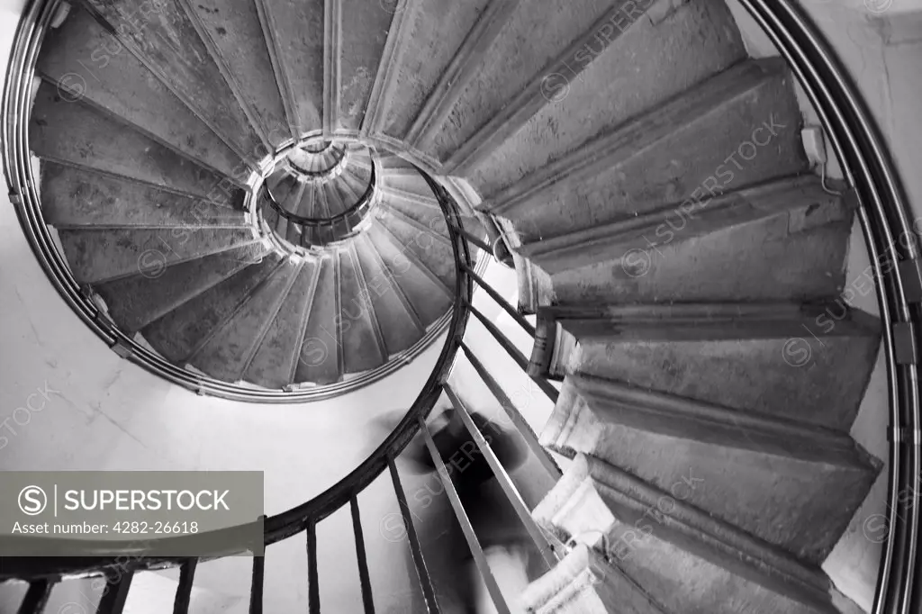 England, London, The City. A person descending the spiral stairs inside the Monument in the City of London.