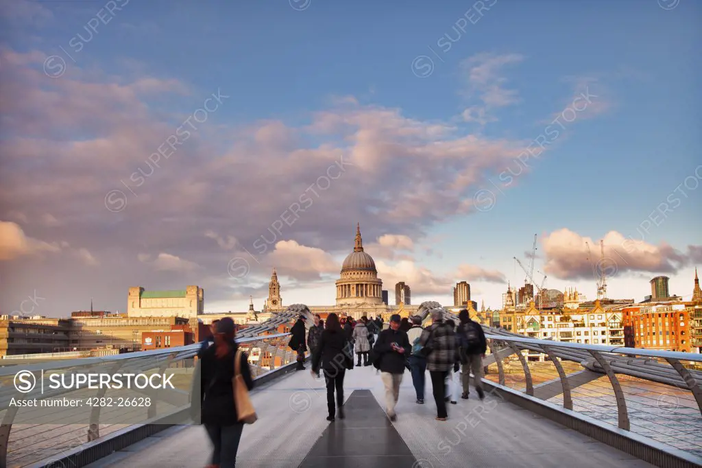 England, London, The Millennium Bridge. People walking across the Millennium Footbridge towards St Pauls Cathedral.
