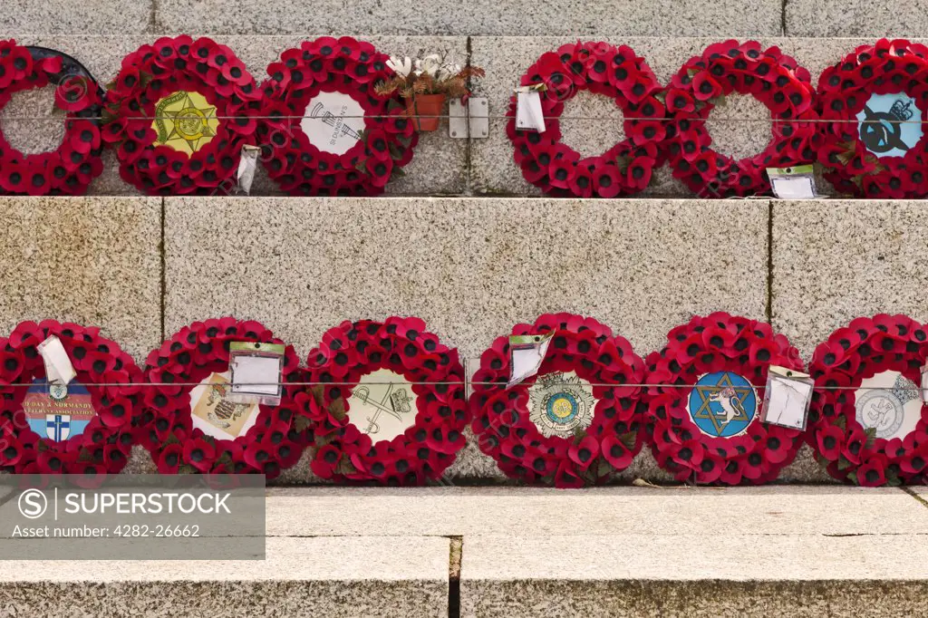 England, Lancashire, Blackpool. Poppy wreaths laid in remembrance at the foot of the war memorial on the seafront at Blackpool.
