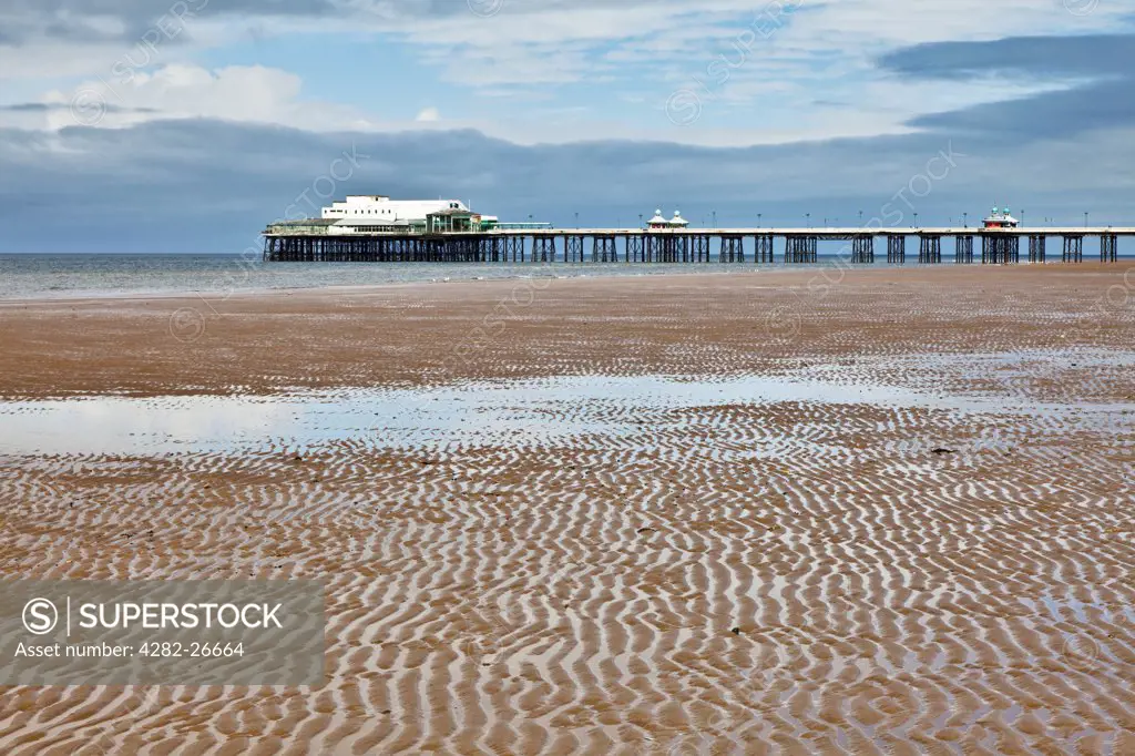 England, Lancashire, Blackpool. Ripples on the sands with the North Pier in the background stretching into the sea.
