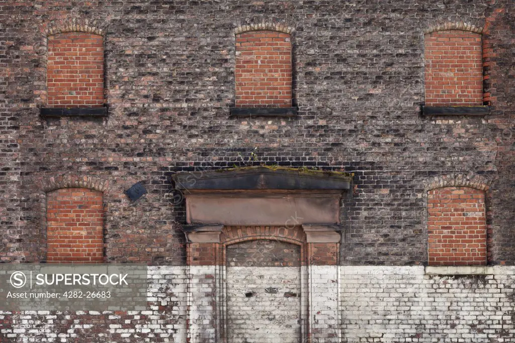 England, Merseyside, Liverpool. Bricked up windows and door of an old warehouse.