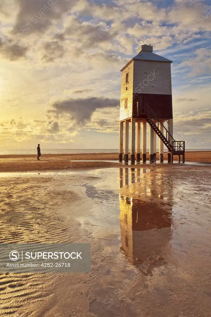 England, Somerset, Burnham-On-Sea. A man standing on the beach looking at Burnham-on-Sea Low Lighthouse, built by Joseph Nelson in 1832.