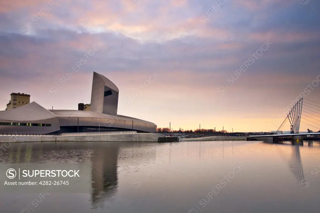 England, Greater Manchester, Manchester. Imperial War Museum North (IWM North) in a spectacular building designed by Daniel Libeskind and the Lowry Bridge at Salford Quays.