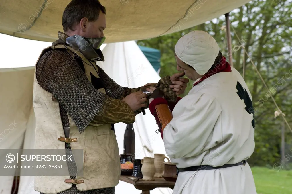 England, Essex, Castle Hedingham. A knight being prepared for battle at a medieval re-enactment at Hedingham Castle.