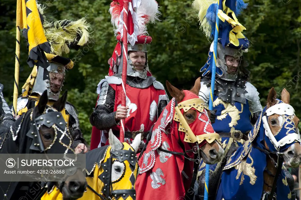 England, Essex, Castle Hedingham. Three Knights of Arkley line up in front of the crowd before a jousting tournament begins at a medieval re-enactment at Hedingham castle.