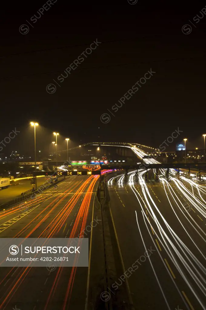 England, Kent, Dartford. Light trails from vehicles travelling to and from the Dartford River Crossing at night.