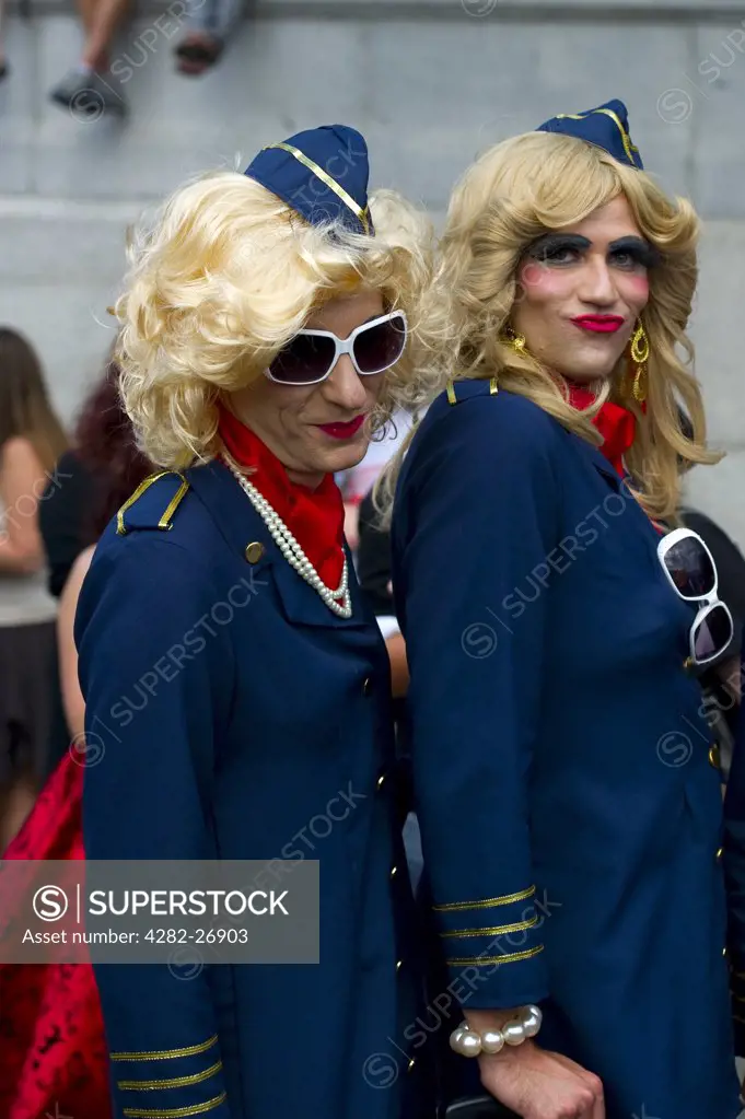 England, London, Trafalgar Square. Two transvestites pose as air stewardesses in Trafalgar Square at Gay Pride 2010.