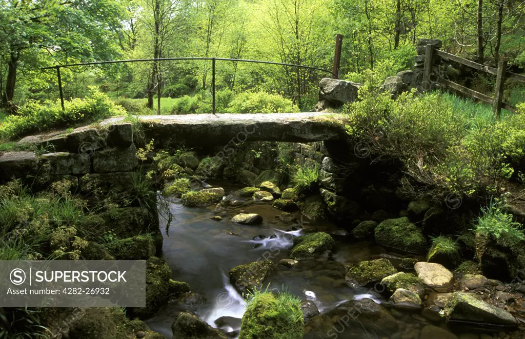 England, West Yorkshire, Hebden Bridge. Old stone slab bridge at Jumble Hole. The area of Jumble Hole is a steep sided wooded valley formed by a fast flowing stream that flows into the River Calder.