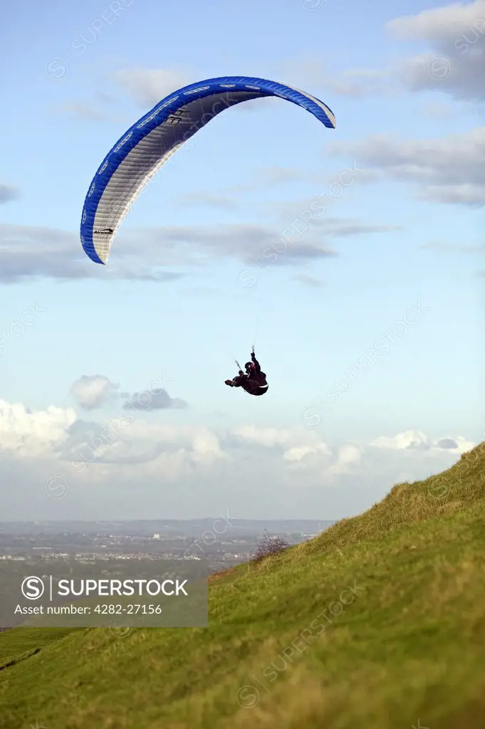 England, West Sussex, Devil's Dyke. Man paragliding over the South Downs.