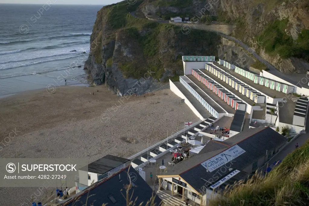 England, Cornwall, Newquay. Multi-coloured beach huts and cafe at Tolcarne Beach in Newquay.