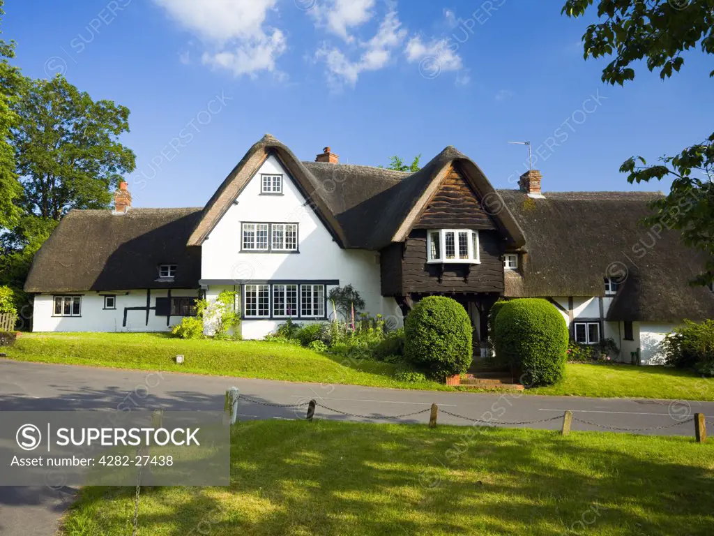 England, Hampshire, Chilbolton. Thatched cottages opposite a triangular road junction in the village of Chilbolton.