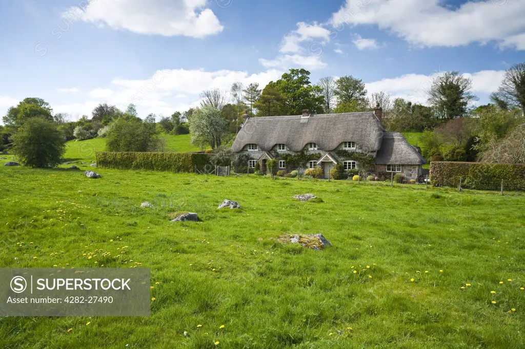 England, Wiltshire, Marlborough. Thatched cottages on Lockeridge Dean, an area with scattered Sarsen Boulders known locally as Grey Wethers.
