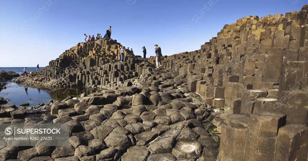 Northern Ireland, County Antrim, Giants Causeway. Tourists exploring the interlocking basalt columns of the Giants Causeway,  a World Heritage Site and National Nature Reserve.