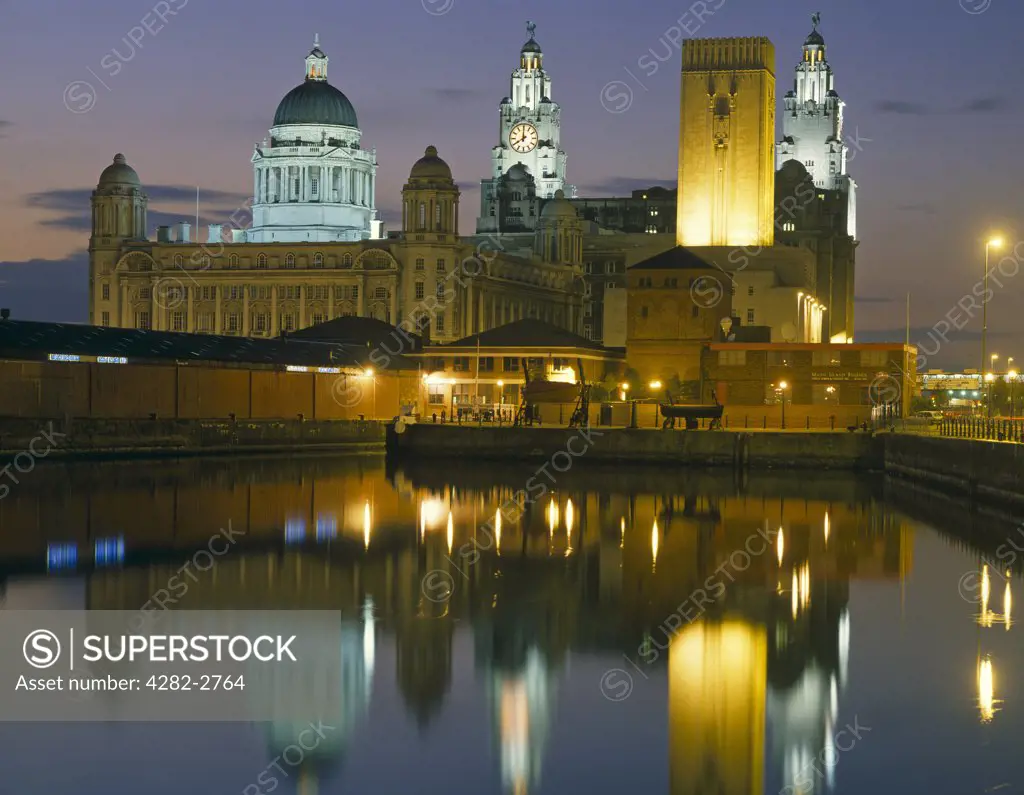 England, Merseyside, Liverpool. The Liver Building reflected in water in the dock.