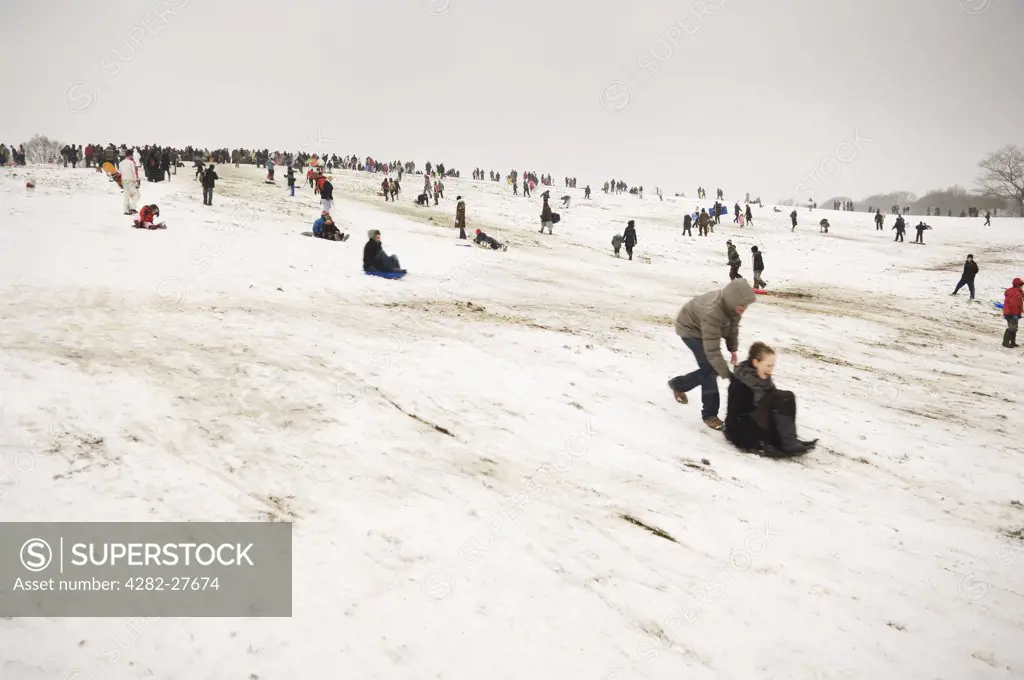 England, London, Highgate. People enjoying the extreme winter conditions by sledging down Highgate Hill.