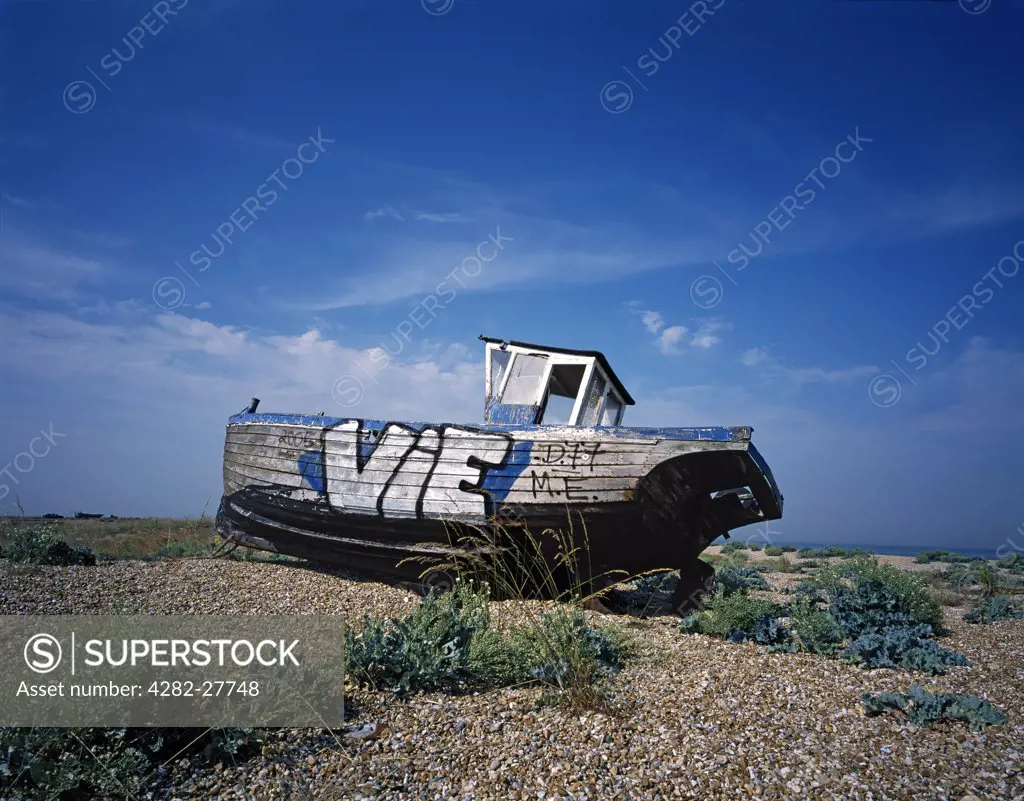 England, Kent, Dungeness. Old beached boat on Dungeness beach. The New York Times once stated 'if Kent is the Garden of England, Dungeness is the back gate'.