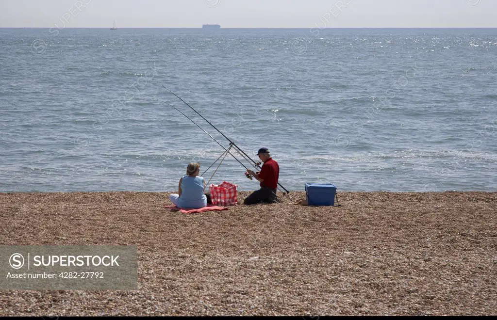 England, Kent, Dungeness. A couple fishing on the beach at  Dungeness.