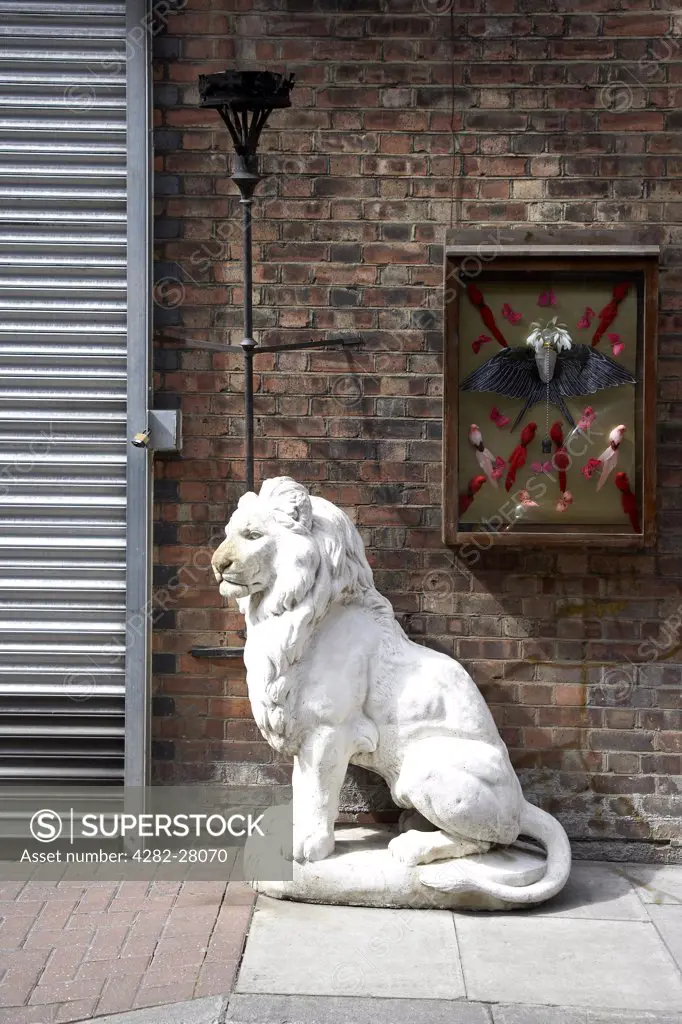 England, London, Brick Lane. A white lion sculpture outside a shop in Brick Lane.