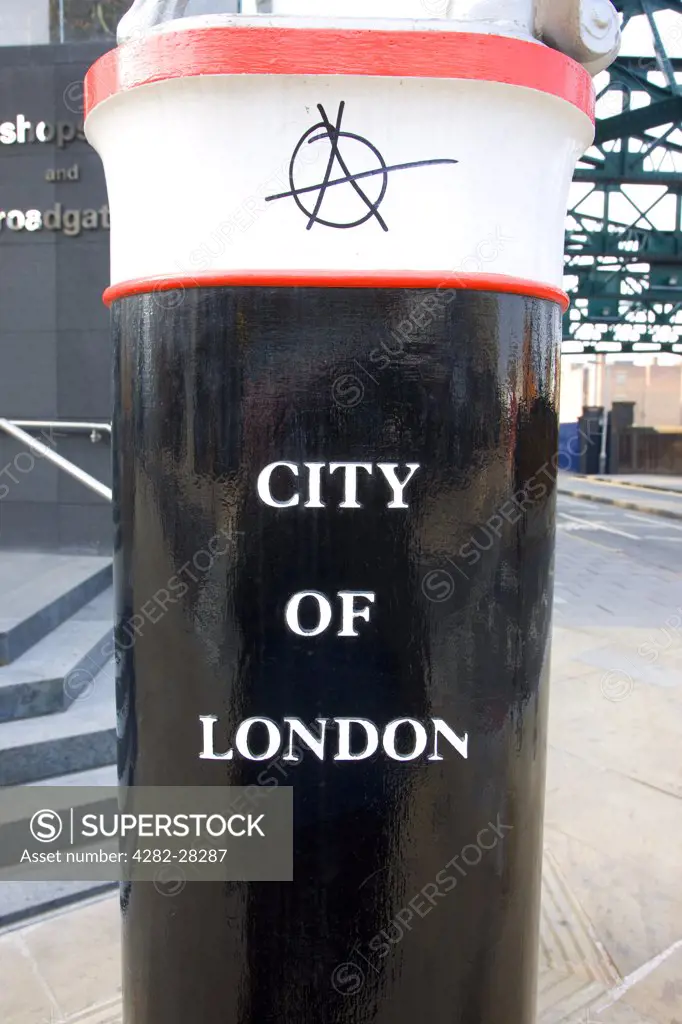 England, London, Bishops Gate. A City of London marker with the anarchy symbol graffitied onto it in Bishops Gate.