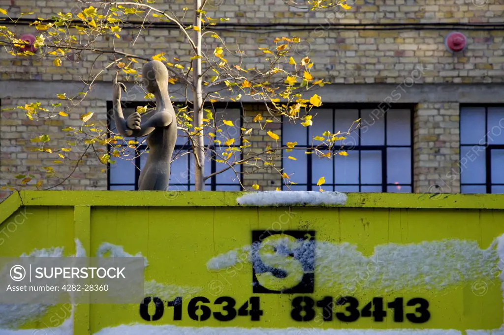 England, London, East London. A shop dummy positioned to make a rude gesture in a skip.
