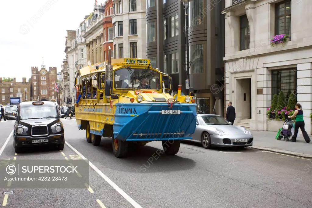 England, London, Westminster. The Duck Tours vehicle driving up St James's. Duck tours offers visitors an opportunity to see London's famous sites by road and from the water using an amphibious vehicle.