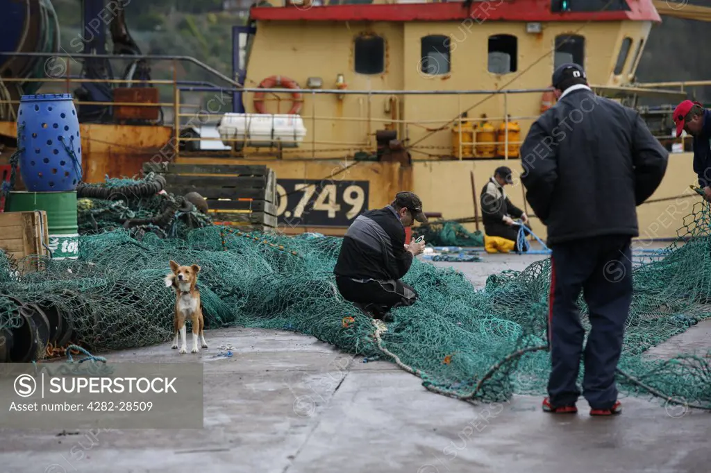 Republic of Ireland, Cork, Kinsale. Fishermen mending nets on the quayside.