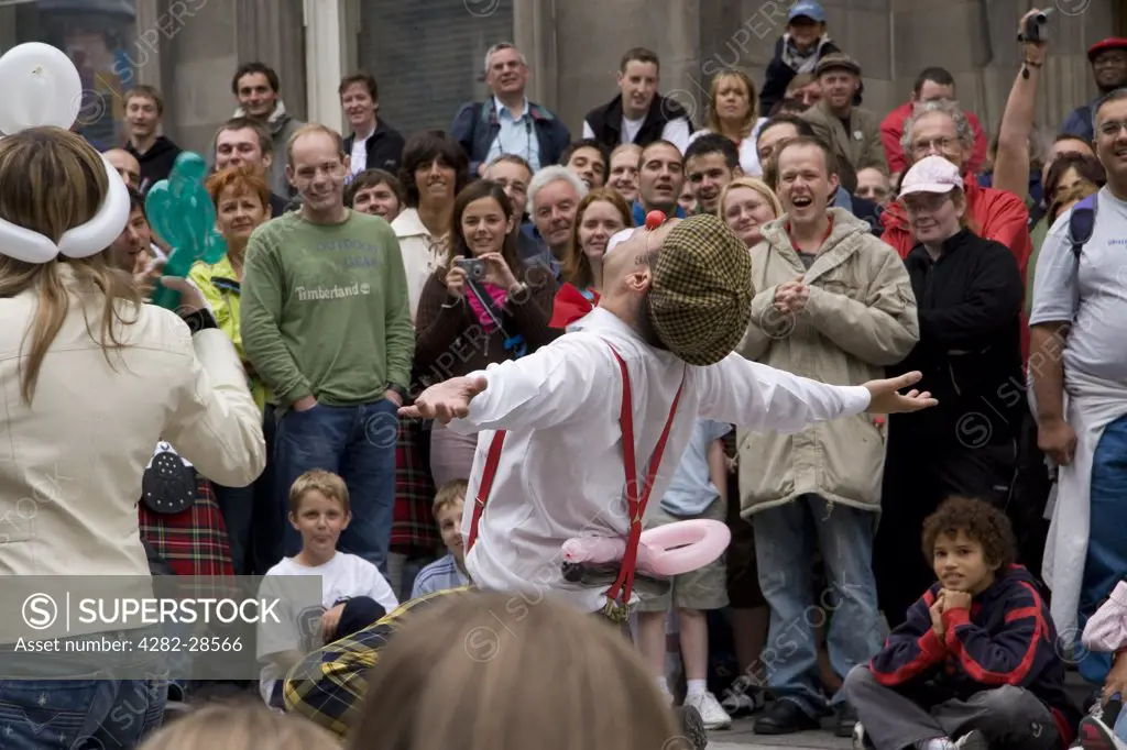 Scotland, Lothian, Edinburgh. Street performers entertain bystanders.