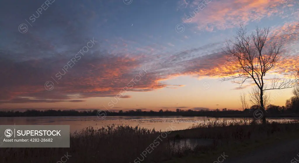 England, Gloucestershire, South Cerney. Sunset at Lake 16 at the Cotswold Water Park. The Cotswold Water Park is formed from over 150 lakes created from the extraction of gravel.