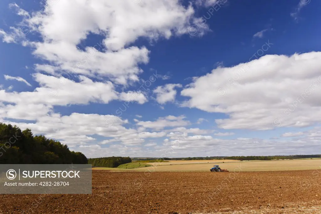 England, Gloucestershire, near Cirencester. Tractor ploughing a large field in the countryside near Cirencester.