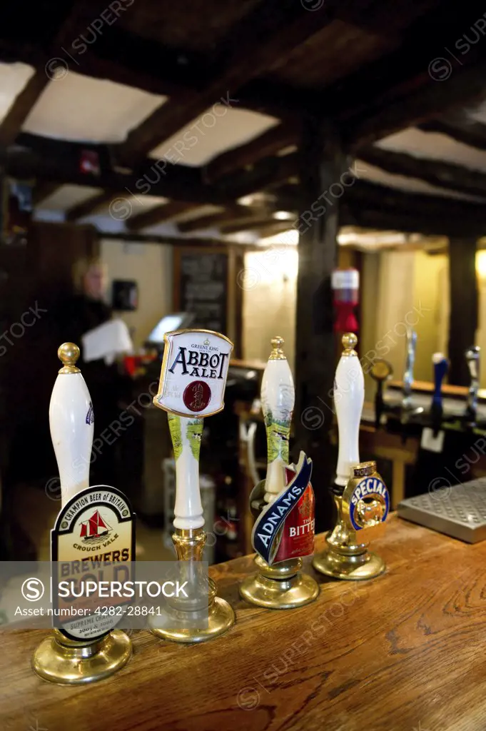 England, Essex, Stock. Beer pump handles on the bar at The Hoop, a freehouse which dates back 450 years.