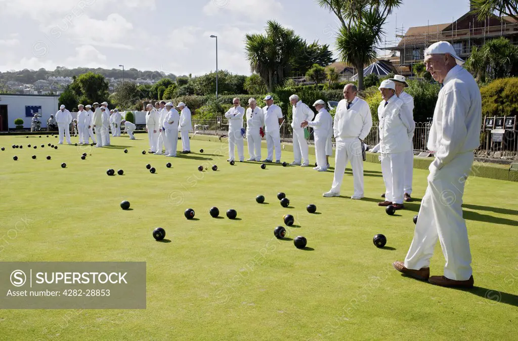 England, Cornwall, Newlyn. Bowlers dressed in white playing Crown Green Bowls at Newlyn Bowling Club.