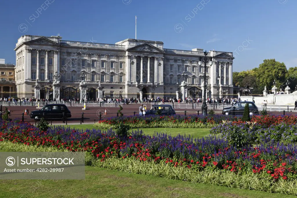 England, London, Buckingham Palace. Black London taxi cabs travelling past Buckingham Palace.