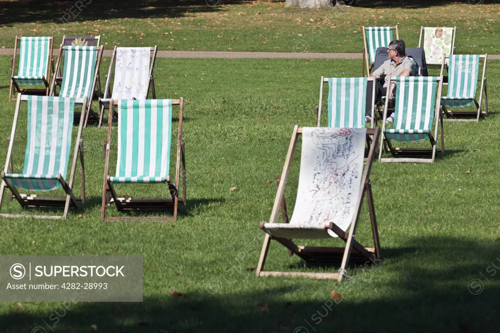 England, London, St James's Park. A man sitting in a deckchair in St James's Park.
