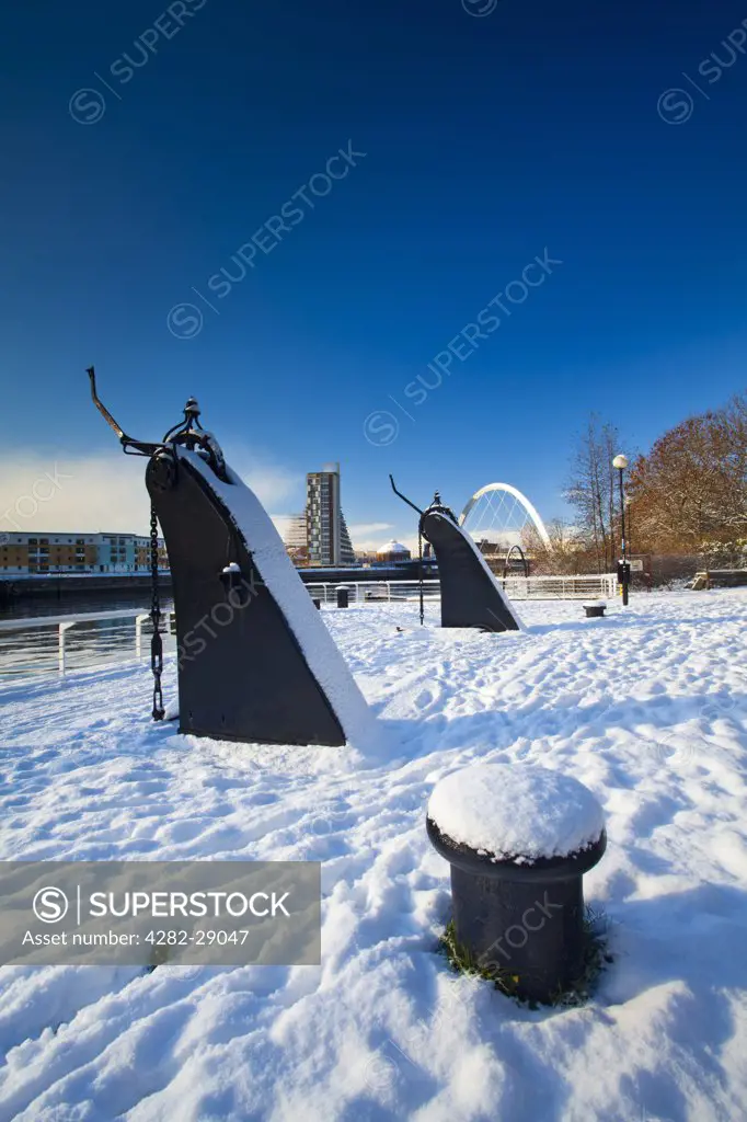 Scotland, City of Glasgow, Glasgow. View over the Clyde Quayside redevelopment area covered in snow towards Glasgow's Clyde Arc bridge, more commonly known as the Squinty Bridge.