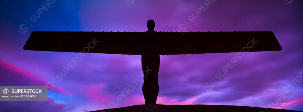 England, Tyne and Wear, Gateshead. The iconic Angel of the North statue by Antony Gormley, silhouetted against an atmospheric sky.