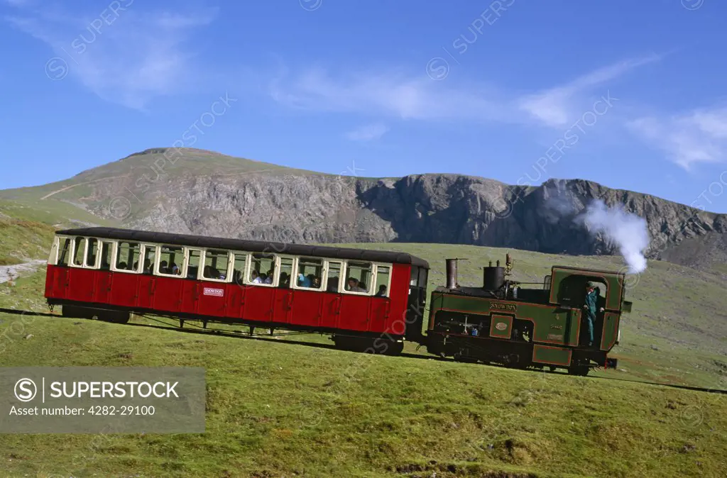 Wales, Gwynedd, Llanberis. A coal-fired steam locomotive (Snowdon No. 4) and carriage ascending the Snowdon Mountain Railway between Hebron Station and Halfway Station. The narrow gauge, rack and pinion railway, first opened 1896, reaches an altitude of just below 3,500 feet.