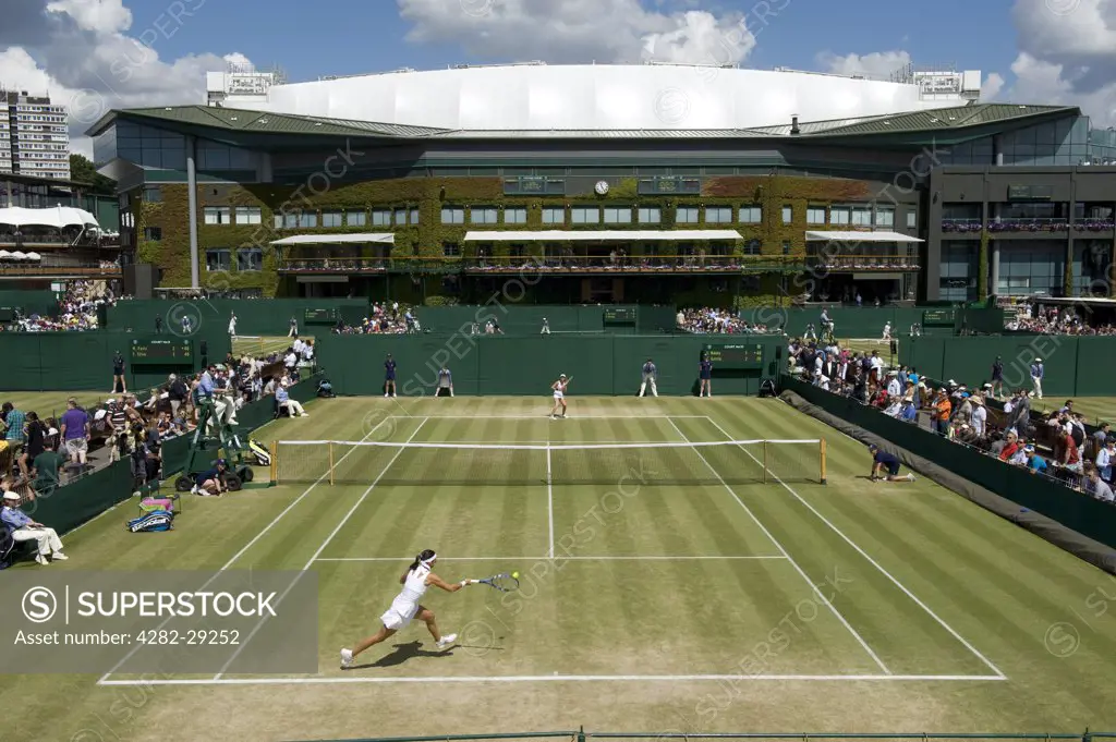 England, London, Wimbledon. A ladies singles match on Court no. 10 with Centre Court in the background at the 2011 Wimbledon Tennis Championships.