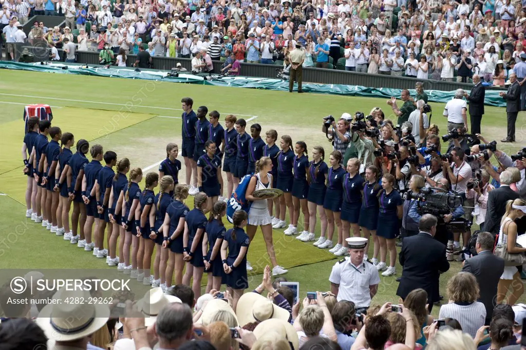 England, London, Wimbledon. Petra Kvitova (CZE) and Maria Sharapova (RUS) leaving centre court through a line of ball boys and girls after the Ladies' singles final at the 2011 Wimbledon Tennis Championships.