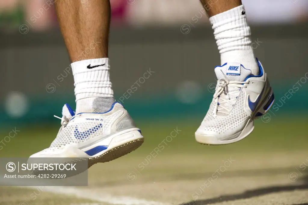 England, London, Wimbledon. Close-up of the feet of Rafael Nadal (ESP) leaving the ground while serving in a match at the Wimbledon Tennis Championships 2011.