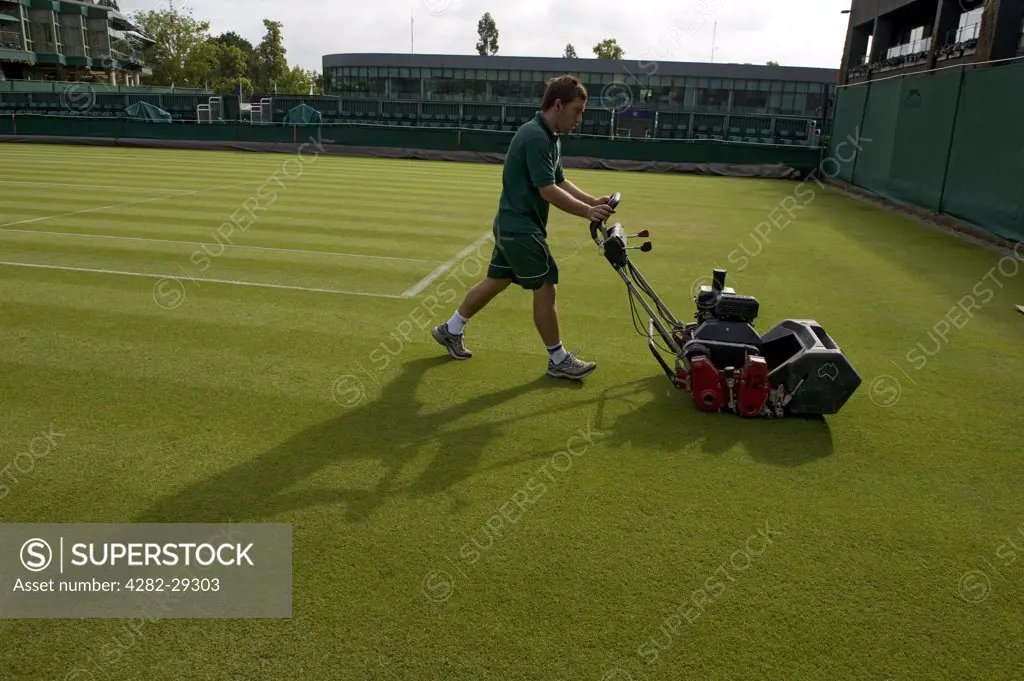 England, London, Wimbledon. A groundsman cutting the grass on Court 16 at The Wimbledon Tennis Championships 2011.