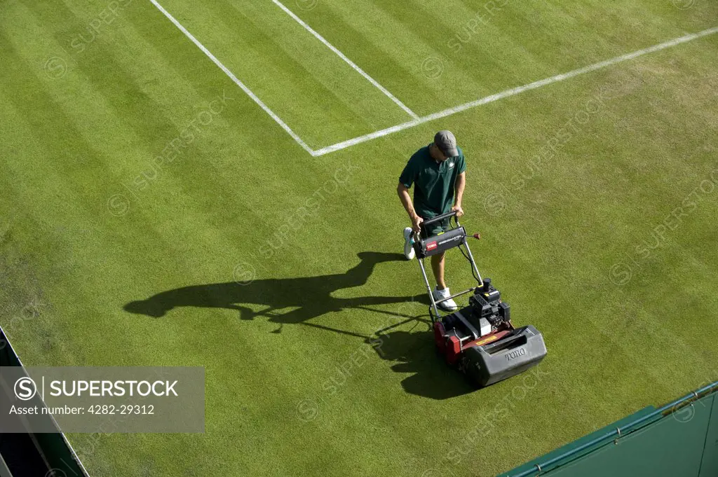 England, London, Wimbledon. A groundsman cutting the grass on Court 4 in preparation for play at the 2011 Wimbledon Tennis Championships.