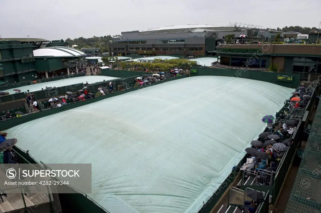 England, London, Wimbledon. Covers on the outside courts during rainfall at the 2011 Wimbledon Tennis Championships.